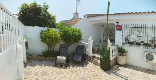 a white house with a gate and a fence at El Rincón del Sotillo beach in Los Alcázares