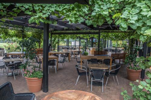 an outdoor patio with tables and chairs and plants at Mick O'Sheas in Hackham