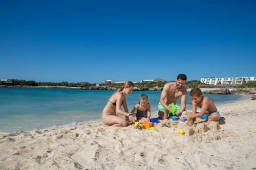 a family building a sand castle on the beach at Grand Sirenis Riviera Maya Resort & Spa All Inclusive in Akumal