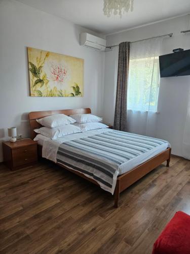 a bedroom with a bed and a painting on the wall at B&B Eva in Ičići