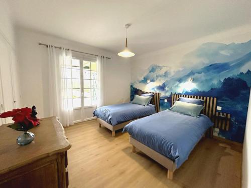 a bedroom with two beds and a painting on the wall at Gîte du nouguès in Garrey