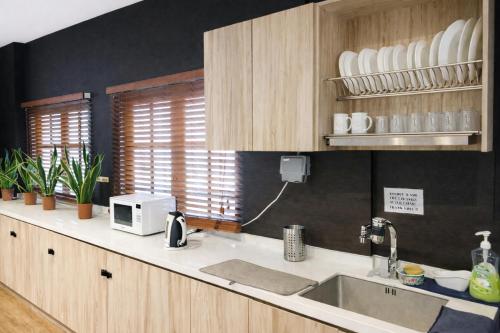 a kitchen with a sink and a microwave at A Hotel Bugis Village in Singapore