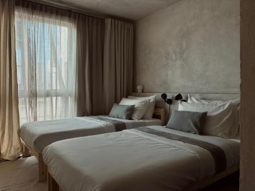 a hotel room with two beds and a window at Casa Mayab in León