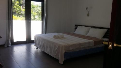 a bedroom with a bed with a towel on it at dilo tree lodge in Sigatoka