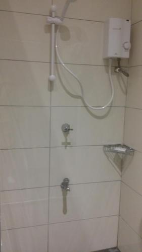 a bathroom with a shower with a hose on the wall at dilo tree lodge in Sigatoka
