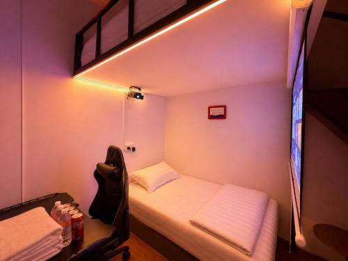 a small room with a bed and a tv at A Hotel Bugis Village in Singapore