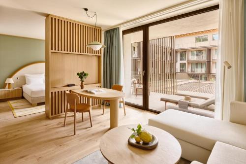a living room with a couch and a table at Falkensteiner Resort Lake Garda in Salò