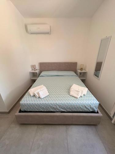 a bedroom with a bed with two towels on it at Blue Sky Sardinia in Sorso