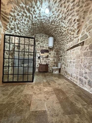 a large room with a stone wall and a window at Kasri Reyyan in Mardin