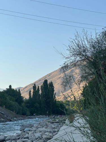 a river with rocks and trees and a mountain at Ugam Glamping in Khumson