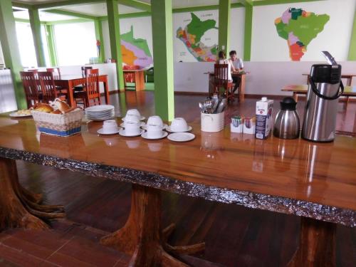 einen Holztisch mit einer Kaffeemaschine darüber in der Unterkunft Tambopata Hostel in Puerto Maldonado