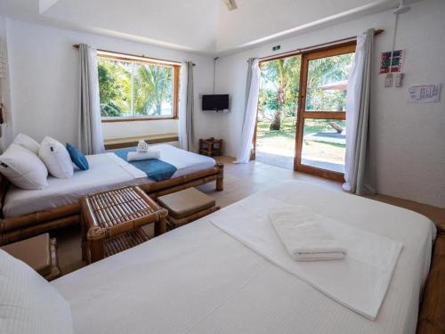 a hotel room with two beds and a window at Elysia Beach Resort in Donsol