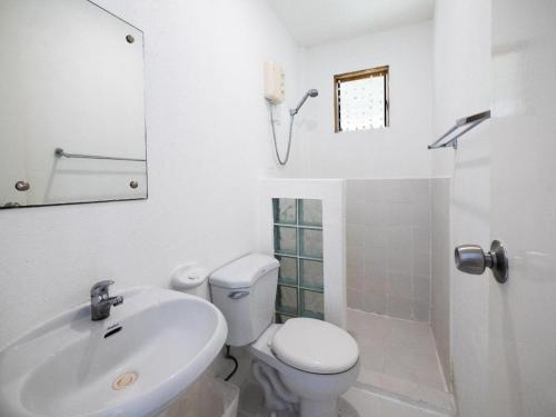a white bathroom with a toilet and a sink at Elysia Beach Resort in Donsol