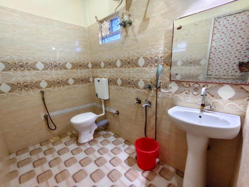 a bathroom with a sink and a toilet and a mirror at Sea Wander Beach Resort in Mandarmoni