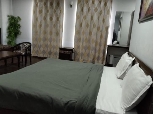 a bedroom with a bed and a table and a mirror at Hotel Ienvo Inn in New Delhi