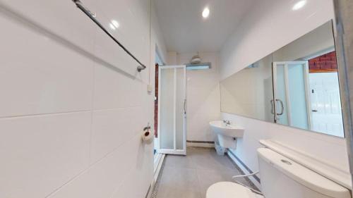 a white bathroom with a sink and a mirror at Changsova Hotel in Ban Chang