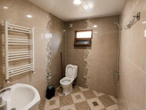 a bathroom with a white toilet and a sink at Four seasons in Kutaisi