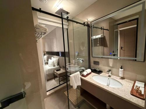 a bathroom with a sink and a large mirror at Lumeirrah Suites in Moga