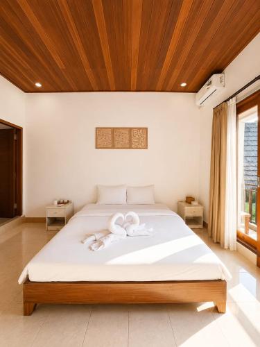 a bedroom with a bed with two towels on it at Lantis Corp Inn in Sengkol