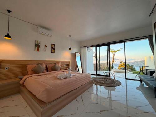 a bedroom with a large bed with a large window at Pinggan Plato in Baturaja