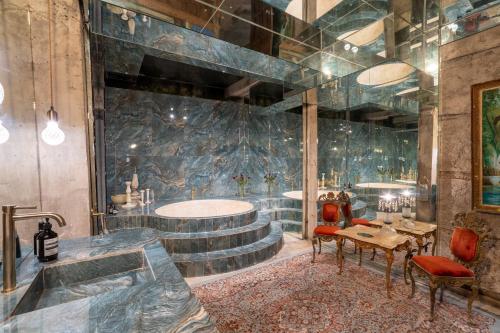 a bathroom with a tub and a table and chairs at The Corduroy Hotel in Canggu