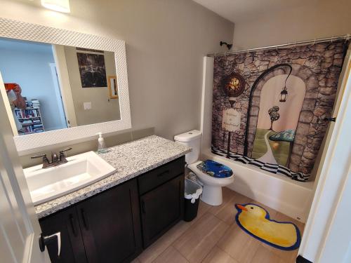 a bathroom with a sink and a toilet and a mirror at Evergreen House in Vancouver