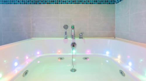 a bath tub with lights in a bathroom at Gapeong Jason Spa Pension in Gapyeong
