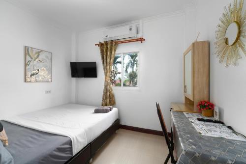 a small bedroom with a bed and a window at Passion Nai Harn Guesthouse in Nai Harn Beach