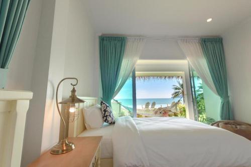 a bedroom with a bed and a large window at Sea Coco Resort in Ban Pak Nam Khem Nu