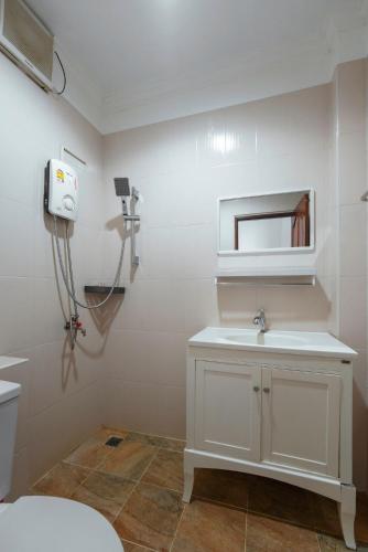 a white bathroom with a sink and a mirror at Passion Nai Harn Guesthouse in Nai Harn Beach