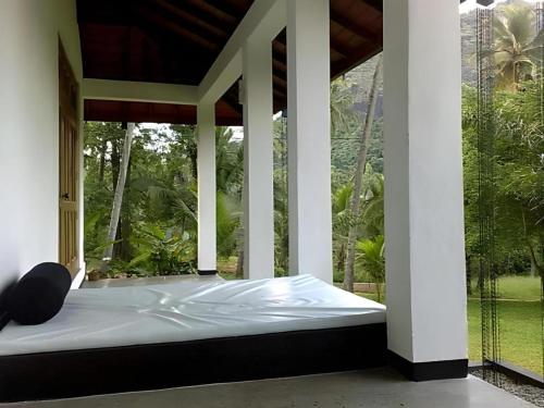 a bed in a room with a large window at Brook Boutique in Madahapola