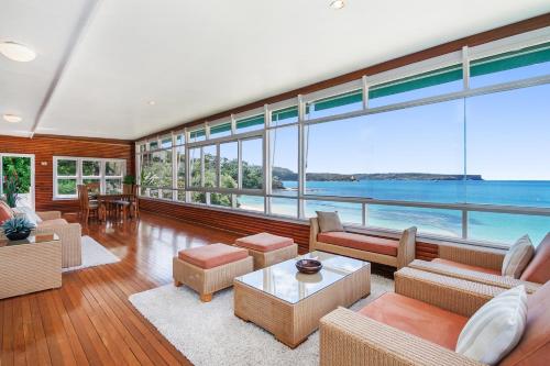 a living room filled with furniture and a lot of windows at The Oriana in Sydney