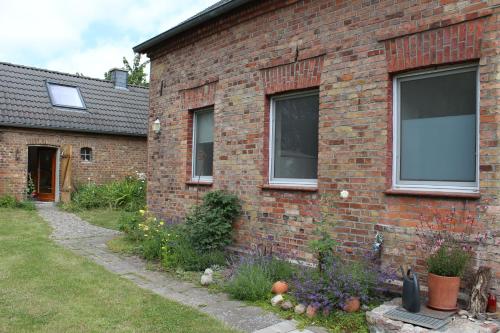a brick house with a window and a yard at Grüne Idylle in Borrentin