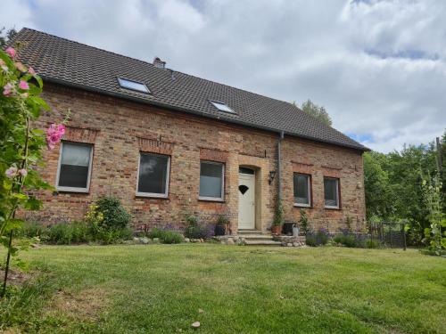 a brick house with a white door and a yard at Grüne Idylle in Borrentin