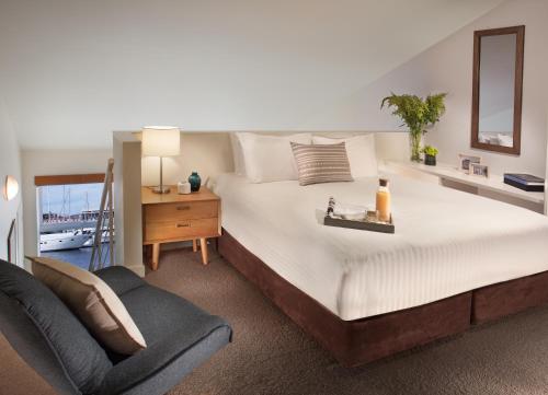 a bedroom with a large bed and a chair at Somerset on the Pier Hobart in Hobart