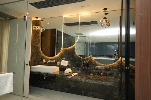 a bathroom with a sink and a large mirror at Estrella The Resort in Karjat