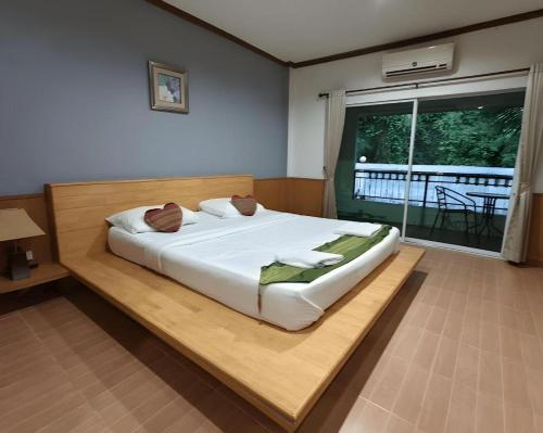 a bedroom with a large white bed and a window at Phakawan Hotel in Ban Nong Chik