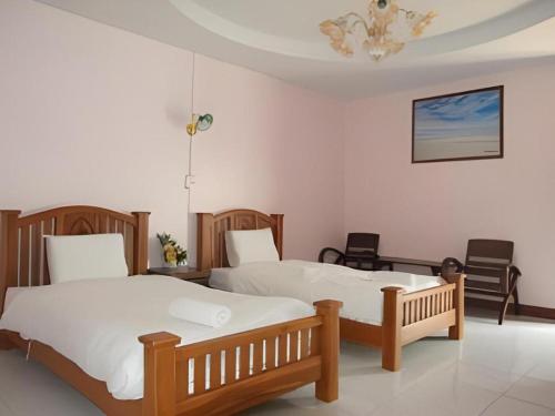 a bedroom with two beds and a chandelier at Erawan Place in Mae Sot