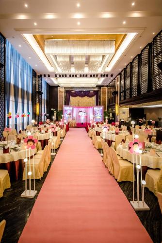 a banquet hall with tables and chairs and a red carpet at Xiang Yun Sha Garden Hotel Shunde in Shunde