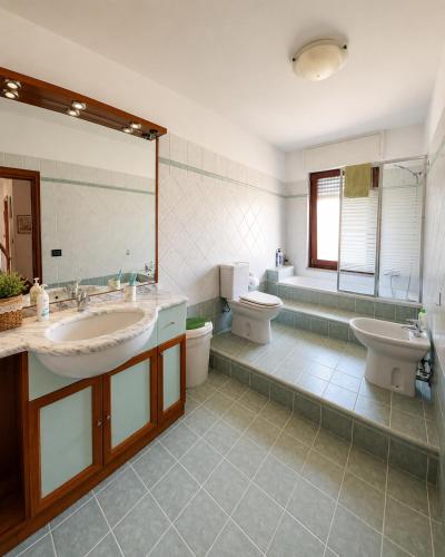 a bathroom with two sinks and a toilet and a tub at La casa del viaggiatore in Codrongianos