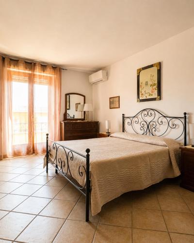 a bedroom with a large bed and a mirror at La casa del viaggiatore in Codrongianos