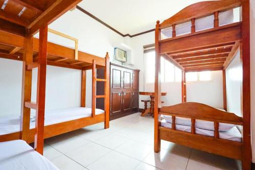 a room with three bunk beds in a house at Mayon Backpackers Hostel in Legazpi