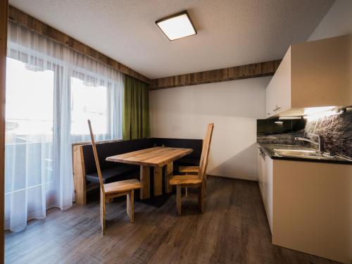 a small kitchen with a wooden table and chairs at Hotel & Apart Central in Fügen
