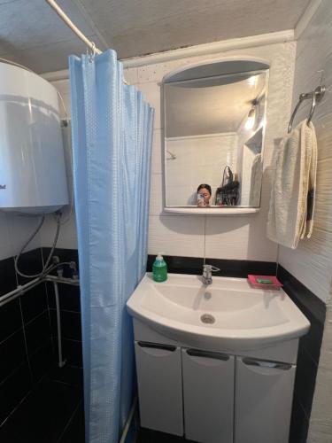 a person taking a picture of a sink in a bathroom at Azamat in Kara-Koo