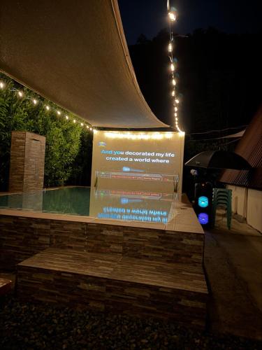 a sign with lights on top of a pool at night at Casa Carmelita in Batangas City