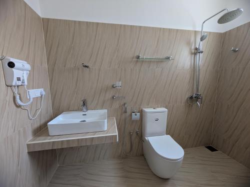 a bathroom with a toilet and a sink and a shower at Casa Luna Home Stay in Dickwella