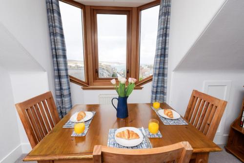 a wooden table with two plates of oranges and a window at North Harbour View, Shetland Islands in Lerwick