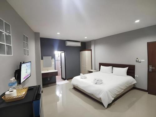 a bedroom with a bed and a desk and a television at Poompimaan House in Udon Border Police