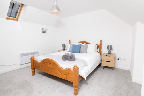 a bedroom with a wooden bed with towels on it at Mowbray's Nook, Shetland Islands in Lerwick