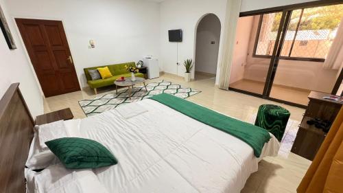 a bedroom with a large bed and a living room at Waterfront vip master room in Muscat